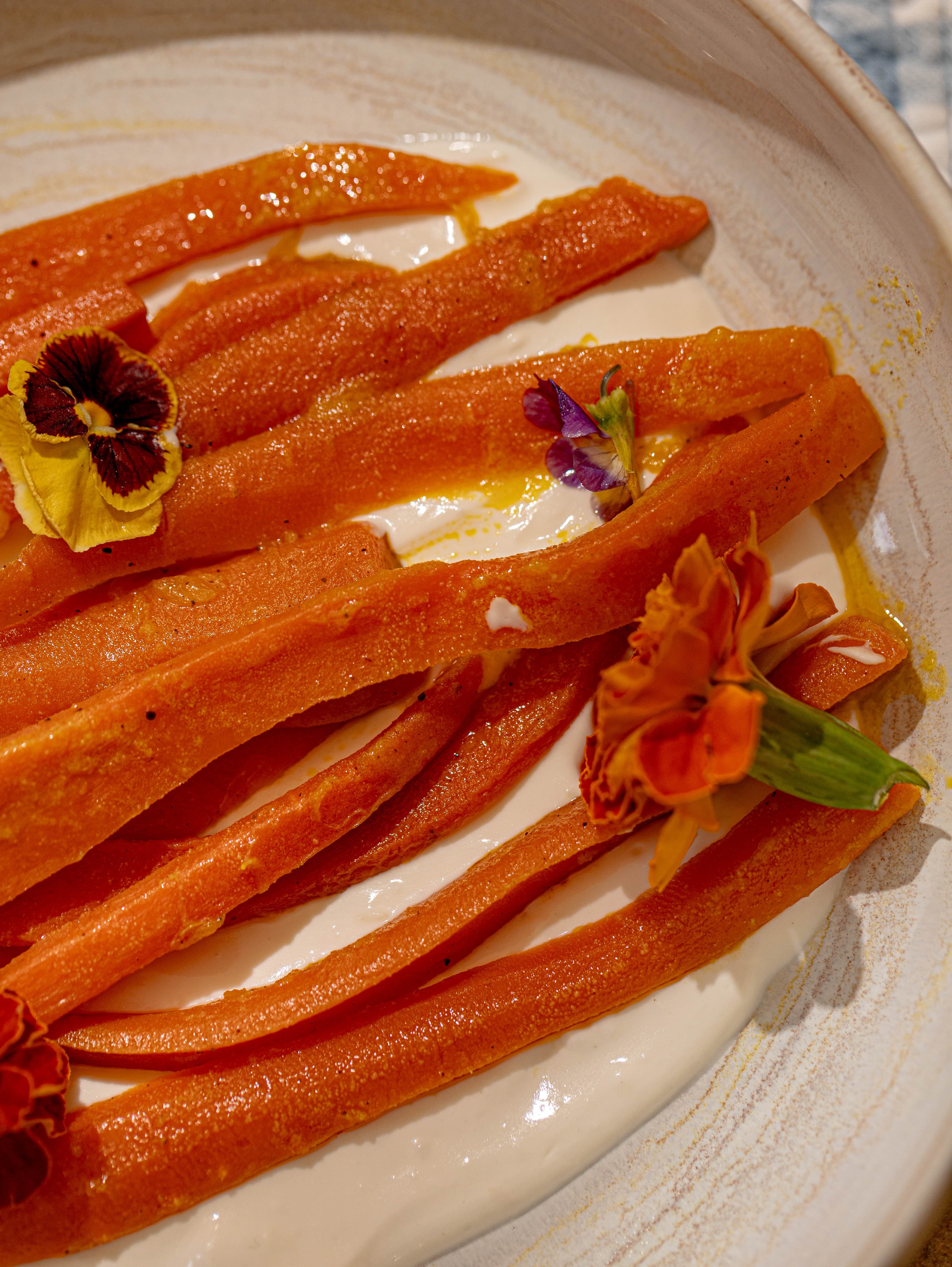 Carottes glacées et fleurs comestibles, de tout près